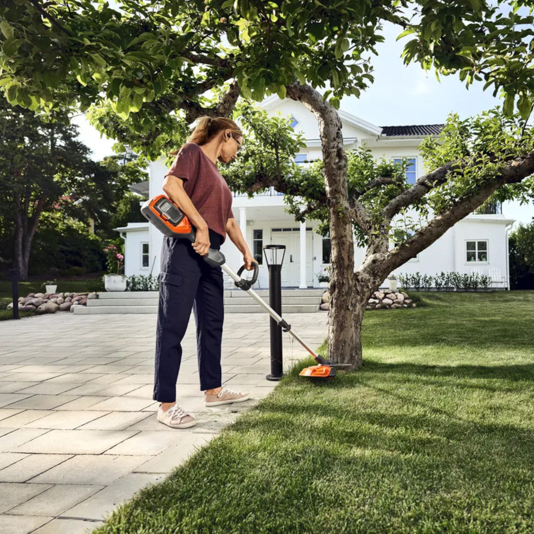 femme utilisant la débroussailleuse à batterie 215iL HUSQVARNA